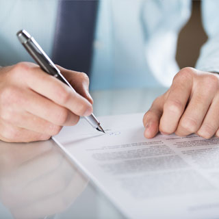 A man's hands signing business documents